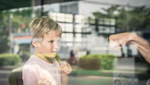 View from outside through window. Little blond caucasian boy play with father Stock Photos