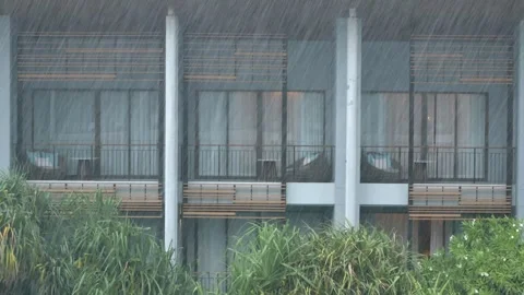 View outside window rain fall against tropical resort hotel Stock Footage 271616383