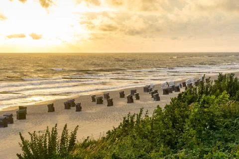 View over beach with beach baskets during sunrise Stock Photos