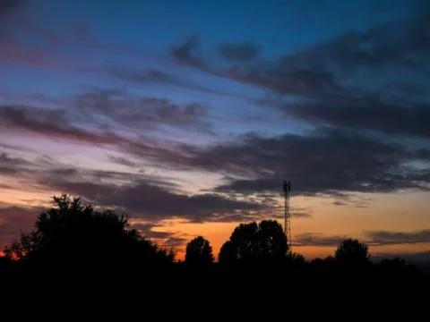 View over a beautiful sunset behind a radio antenna tower. Stock Photos