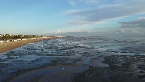 View over boats at low tide at Southend on sea showing the beach and huts Stock Footage 165328982