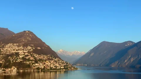 View over City and Alpine Lake with Mountain and the Moon Vídeos de archivo 111574110