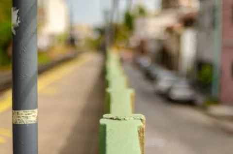 View over a light green wall with a yellow line and some cars, with shallow d Stock Photos