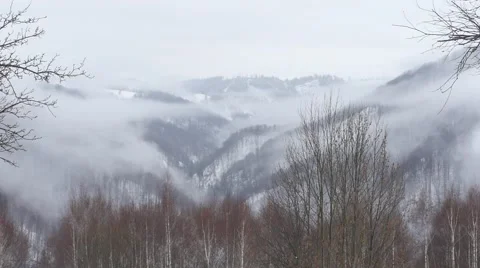 View over the mountains which are loaded with snow with wisps of fog that 724 Video stock 58908606