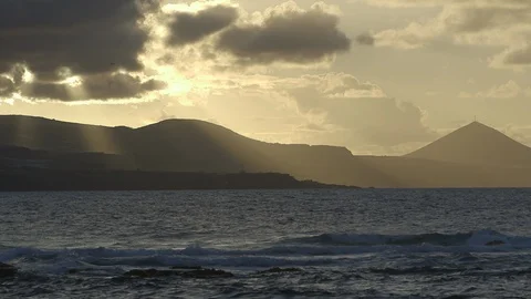 View over ocean with mountains silhouettes against sun backlight Stock Footage 86464807