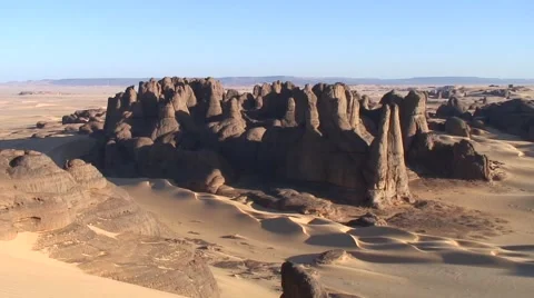 View over rock formations in sandy Saharan desert in the afternoon sun Video stock 68497263