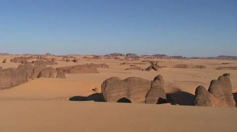 View over rock formations in sandy Wadi in the Saharan desert in the morning Stock Footage 68497330