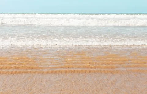 View over sandy beach of Atlantic Ocean with waves coming in perfect parallel Stock Photos