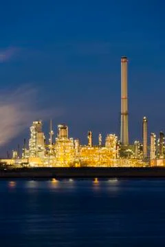 View over the Scheldt river to a large oil refinery with night blue sky, illu Stock Photos