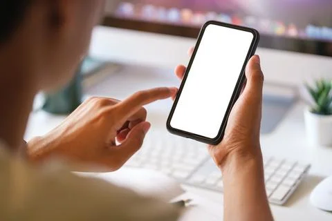 View over shoulder of man hands holding smart phone. Empty screen for your .. Stock Photos