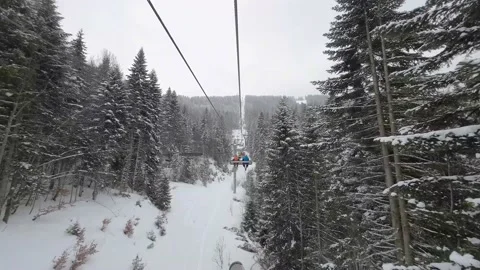 View over snowy mountain winter forest with chair lift at ski resort Stock Footage 176718015