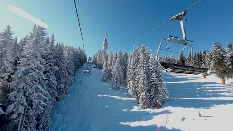 View over snowy mountain winter forest with chair lift at ski resort Stock Footage 246675961