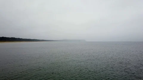 View over still ocean on a dreary and foggy day in autumn Stock Footage