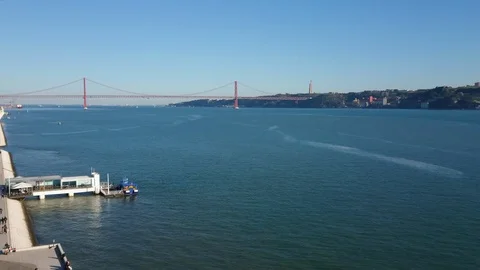 View over Tagus River and 25 de Abril Bridge in Lisbon, Portugal on sunny day Stock Footage 95927208