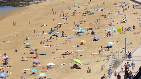 View overlooking the Grande Plage filled with people enjoying the warm weather Видео 340209624