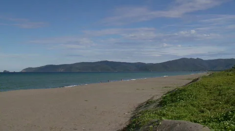View on the Pacific Ocean over a sandy beach towards mountain range Stock Footage 559284