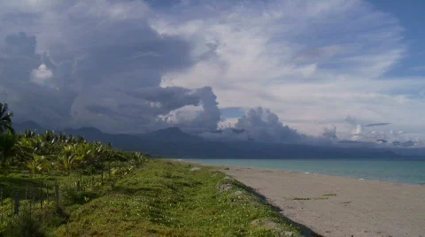 View on the Pacific Ocean over a sandy beach towards mountain range Stock Footage 559285