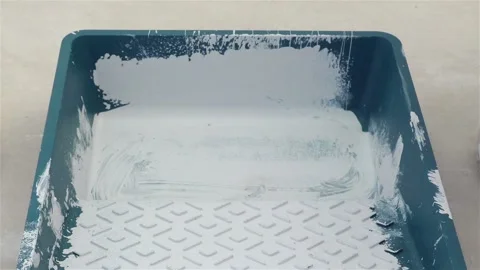 View of Painter worker pours paint into a pallet and prepares for painting Stock Footage 125708491