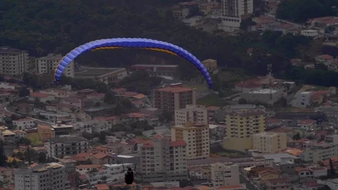 View of para glider with colourful wing chute floating slow motion across Stockbeeldmateriaal 102064771