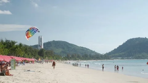 View of parachute while landing on tropical sea sand beach area with people.. Vídeos de archivo 278387530