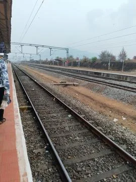 View of parallel railway tracks next to a train station platform Stockfoto's
