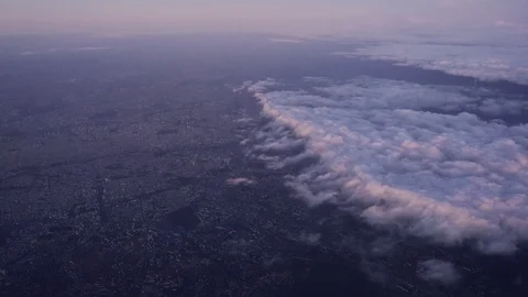 View of Paris from above the clouds during a pink, hazy sunset from a Stock Footage 124912797