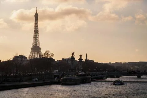View of Paris at sunset with the Eiffel Tower and the bridge Alexander III... Stock Photos