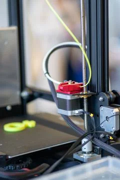 View of a part of a 3D printer printing a green symbol from plastic Foto stock