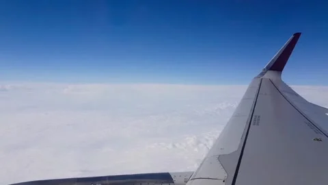 View from a passenger aircraft window showing the wing extending above a thick l Stock Footage 336960508