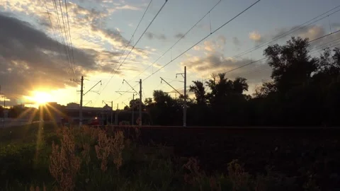 View of the passenger train, sunset, and surrounding city landscape Stock Footage 137672273