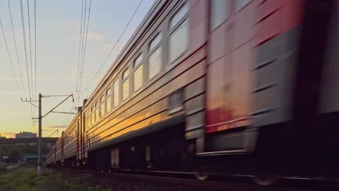 View of the passenger train, sunset, and surrounding city landscape Stock Footage 165076844