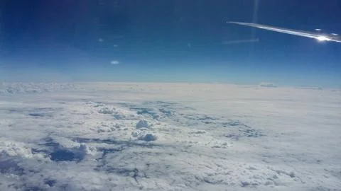 View from a passenger window during flight above an extensive cloud layer under  库存照片