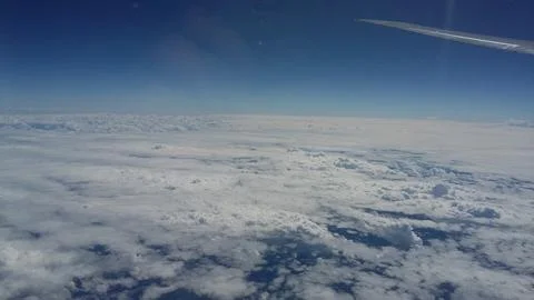 View from a passenger window during flight above an extensive cloud layer under  Stockfoto's