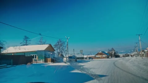 View from a passing car window of winter wooden houses in Russia, the village of Stock Footage 228883447