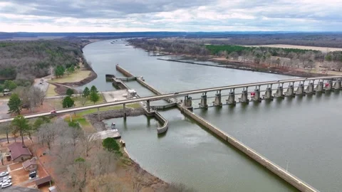 View passing diagonally over the lock, dam, and bridge on the Arkansas River. Video stock 266918495