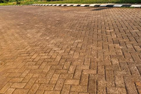 View of a paved road made of interlocking concrete bricks, illuminated by w.. 스톡 사진