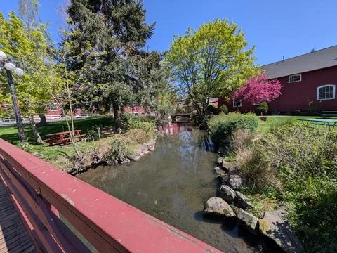 View from a pedestrian bridge overlooking a stream, picnic benches Stock-Fotos