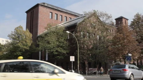 View of pedestrians on a street bordered by a red brick building 動画素材 60965201