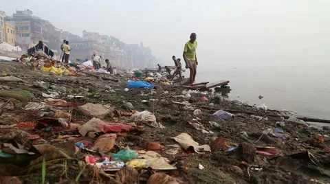 View on people going through waste at dirty shore of river Ganges. Stock Footage 50525092