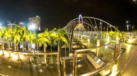 View as people pass by on a bridge at night in Singapore Stock Footage 64085557