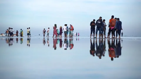 View of people reflected on the wet sand of Cox's Bazar, Bangladesh. 스톡 동영상 335024311