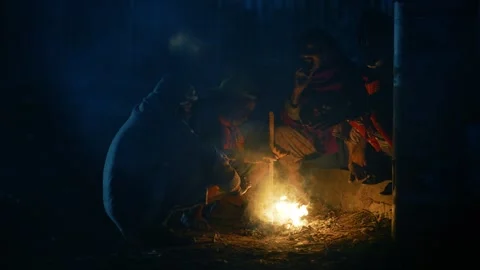View of people sitting around a small fire at night, Bangladesh. Stock Footage 335551270