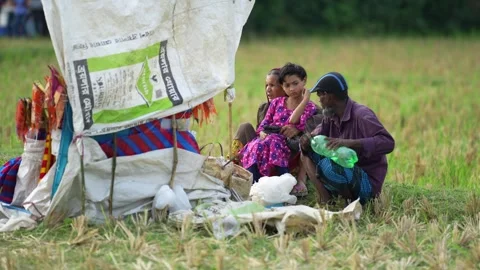 View of people sitting by a makeshift stall in a field, Bangladesh. Stock Footage 335015309