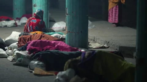 View of people sleeping on the ground at night in Bogura, Bangladesh. 스톡 동영상 335551226