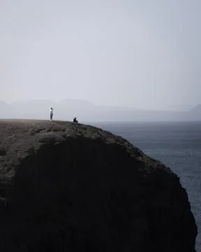 View of people standing on the cliffs looking at the ocean in Playa del Papag Stock Photos