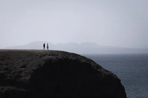 View of people standing on the cliffs looking at the ocean in Playa del Papag Stock Photos