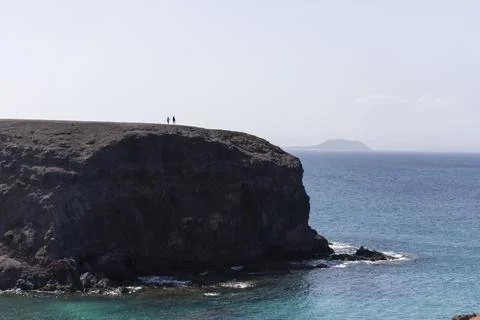 View of people standing on the cliffs looking at the ocean in Playa del Papag Stock Photos