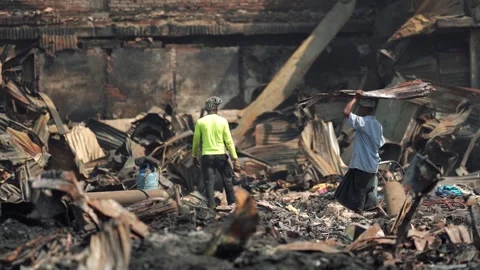 View of people walking through fire ruins in Dhaka, Bangladesh. Vídeos de archivo 335600256