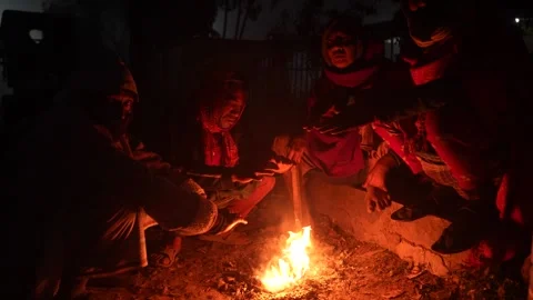 View of people warming themselves by a fire at night, Bangladesh. Video stock 335550925
