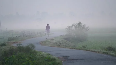 View of a person walking on a winding road in Bogura, Bangladesh. Stock Footage 335595573
